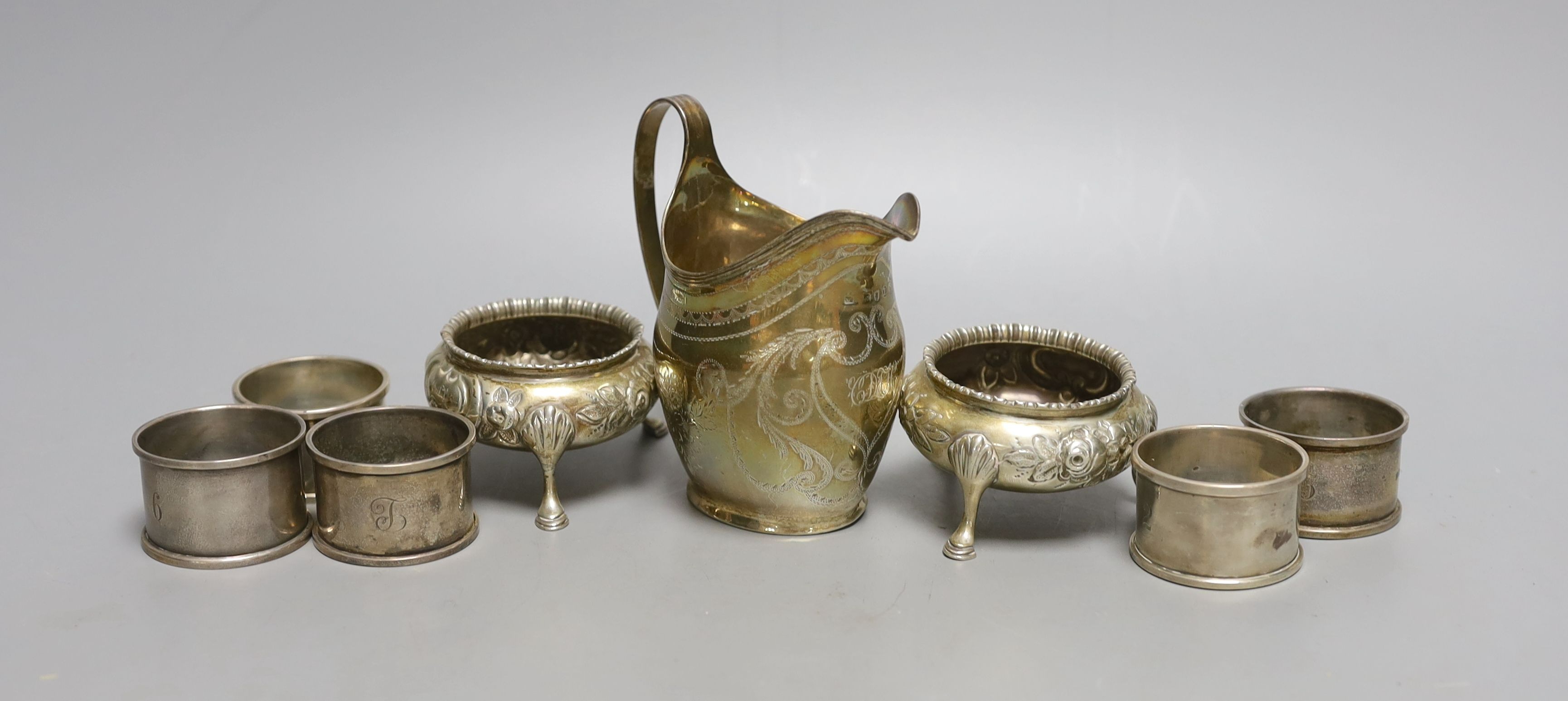 A George III silver cream jug, London, 1806, 10.6cm, a pair of Victorian silver bun salts and four silver napkin rings, 9oz.